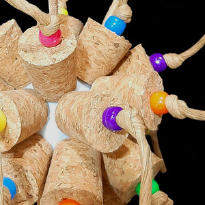 Two dozen cork stoppers with pony beads tied onto a perforated golf ball base with twisted paper cord. The toy hangs from a strip of veggie tanned leather lace. Designed for intermediate sized birds such as small conures, cockatiels, quakers, ringnecks, etc. up to slightly bigger birds that like softer textured toys. Measures approx 5" by 10" including link.