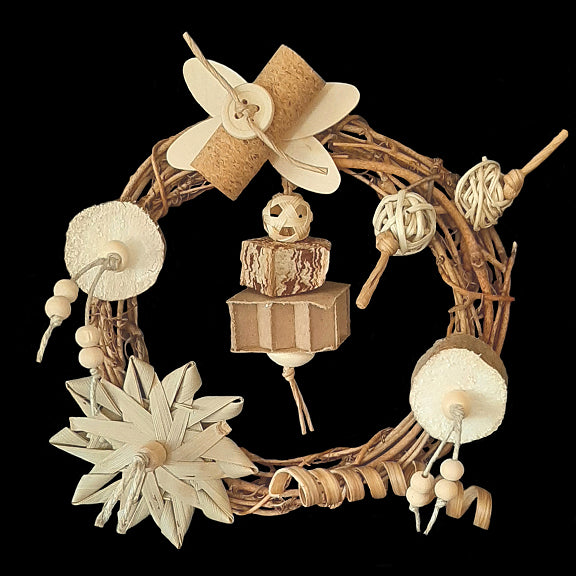 A 6 inch grapevine wreath filled with lots of beak tempting, easy to chew and shred materials including super soft sola, cork, mini vine balls, thin wood paddles, a crunchy palm leaf flower, mahogany chunk, cane spring, cardboard honeycomb block and lots of little wood snap beads. Designed for small to intermediate birds who like softer textures.  Attaches to the side of your bird's cage with zip ties (included).