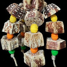 Load image into Gallery viewer, A large mahogany pod with cascading legs of mahogany pod chunks and brightly colored wood beads strung on jute cord. Two crunchy palm leaf bows add another texture for shredding delight! Designed for birds that prefer soft, crunchy textures. Measures approx 5&quot; by 12&quot; including link.
