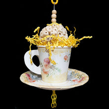 Load image into Gallery viewer, Your bird is sure to have a party with this super-soft sola ball nestled inside a paper tea cup and saucer! The cup is stuffed with crinkle paper shred and has a cork stopper hidden inside. Strung on stainless steel wire with small wood snap beads and pla

