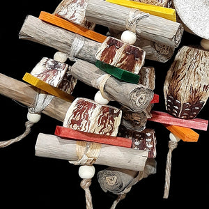 Your bird will think it's hit the jackpot with this toy! The base is a 3 - 3-1/2" yucca round with six arms of banana leaf rolls, mahogany chunks, brightly colored mini pine wood slats and wood snap beads strung on jute cord. At the bottom are two large mahogany pods with more pine slats and snap beads.